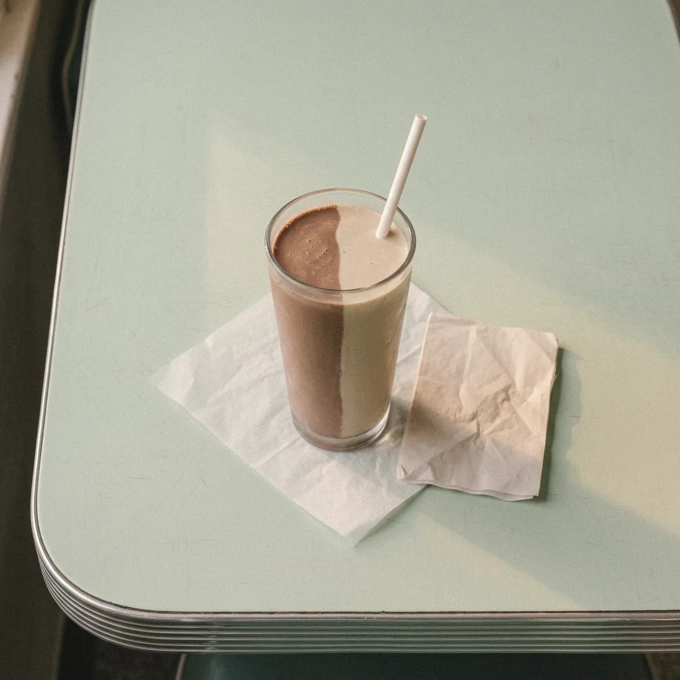 A tall milkshake split half chocolate and half coffee, seen from above
